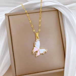 Detailed shot of gold butterfly pendant with pink enamel and sparkling crystals