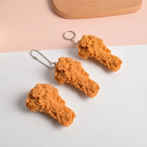 Dettaglio di portachiavi a coscia di pollo fritto dorato con consistenza realistica
