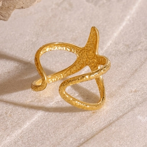 Minimalist gold starfish open ring with hammered texture on a neutral stone background