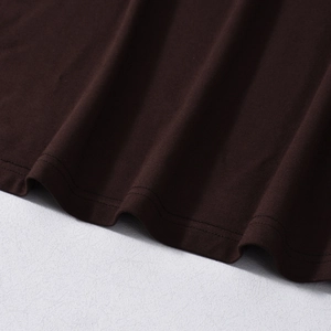Detailed macro view of chocolate brown knitted fabric texture and double-stitch hemline seam