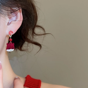 Detail of red festive ox earrings with Fu character studs and soft flocked texture