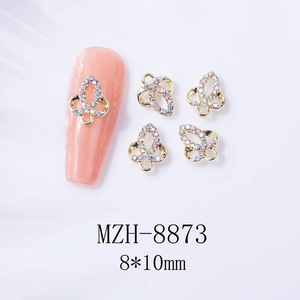 Vue macro détaillée de bijoux d'ongles nœuds dorés 8x10mm avec strass irisés de type AB