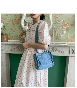 Blue denim crossbody bag detail with silver metal buckle and adjustable shoulder strap