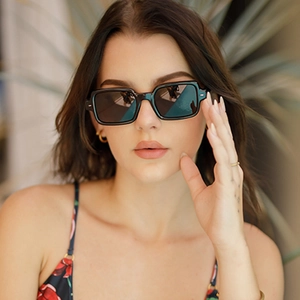 Close-up of retro black square sunglasses with thick frames worn by a female model