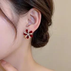 Elegant red velvet flower stud earrings with zircon and pearls worn on model ear