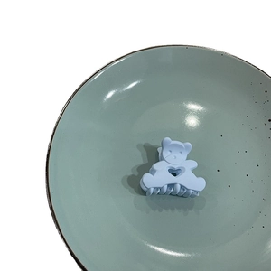 Cute macaron blue bear hair claw clip with heart hollow design on green ceramic plate