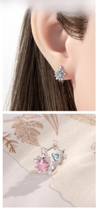 Detailed view of silver star earrings with pink and blue heart-shaped cubic zirconia crystals