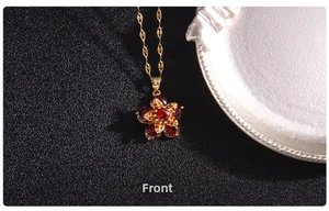 Macro shot of gold four-leaf clover necklace with red gemstones and floral detailing