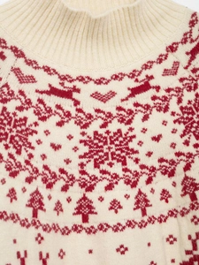 Close-up of Fair Isle knit sweater collar with red reindeer and snowflake patterns