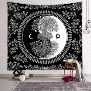 Detail of black and white bohemian tree of life tapestry hanging on a white brick wall