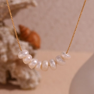 Detalle del collar de cadena de serpiente bañada en oro 18K con siete perlas naturales