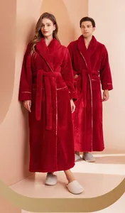 Detailed close-up of thick red flannel robe featuring white piping on sleeves and pockets