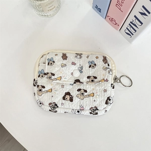 Detailed macro view of white quilted cartoon dog coin pouch with a metal key ring attachment