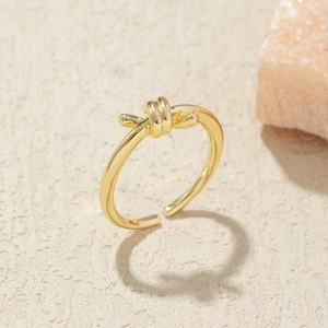 Macro detail of gold knot ring featuring a high-polished double row infinity design