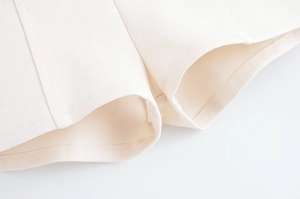 Detailed macro view of the cream white double-sided fabric hem and fine stitching detail