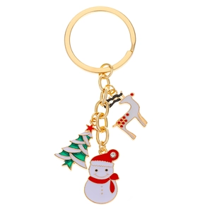 Detailed view of enamel snowman, reindeer, and Christmas tree charms on gold keychain