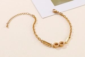 Detailed view of gold infinity charm bracelet with adjustable lobster clasp and link chain