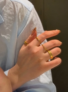 Detailed view of four-piece gold plated textured rings with small crystal accents
