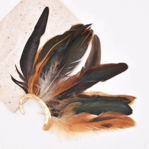 Close-up of vintage peacock feathers and golden metal base on a white background
