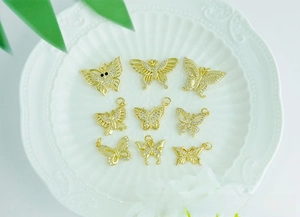 Macro shot of 18K gold-plated butterfly charms with micro-pave cubic zirconia on a plate