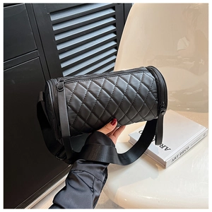 Detail einer schwarzen gesteppten Zylindertasche mit breitem Gurt und Metallreißverschluss