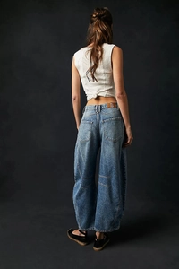 Détail d'un jean large à taille haute avec poches arrière et écusson de marque en cuir