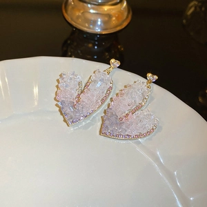 Detail of heart-shaped earrings with white crystal druzy and pink rhinestone accents