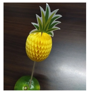 Detail of yellow honeycomb pineapple paper topper on a wooden skewer stuck in lime