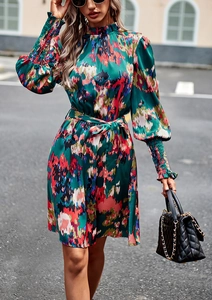 Foto street style di un vestito lungo a fiori verdi con collo alto e cintura in vita