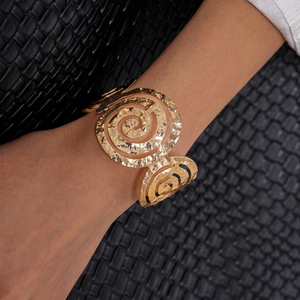 Détail du grand bracelet jonc spirale doré avec une texture en métal martelé