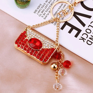 Macro shot of gold-plated red handbag keychain encrusted with crystals and beads