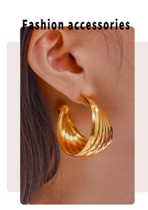 Detailed view of layered gold twist hoop earrings showing luxury texture and finish