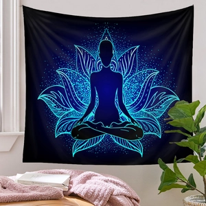 Detail of a meditation yoga tapestry with a blue lotus flower and a silhouette on a wall