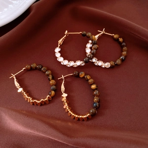 Detailed view of vintage 18k gold plated hoop earrings with tiger eye beads and crystals