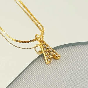 Double-layered golden stainless steel necklace with a sparkling rhinestone letter A pendant