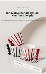 Detailed view of striped ceramic mug with creative spherical bead handle and glossy finish