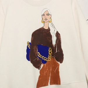 Front view of beige sweatshirt featuring a stylish woman illustration with blue chain bag
