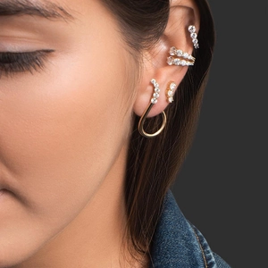 Golden multi-layer C-shaped ear cuffs with zircon stones on model's ear in high quality