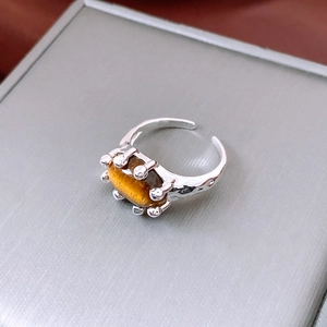 Detail view of oval tiger eye stone ring with hammered silver texture and open band