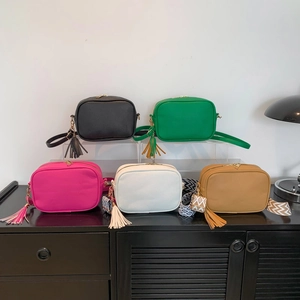 Minimalist wide strap crossbody bags in colorful pebbled leather with tassel charms