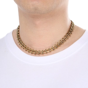 Close-up of 12mm gold trapezoid link chain necklace worn on a model with white shirt