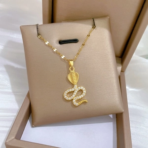 Detailed macro view of gold-plated snake pendant with sparkling white cubic zirconia pavé