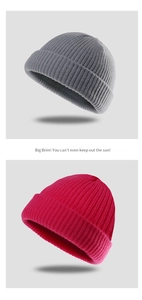 Detail view of knitted beanie textures in grey and rose red with stylish ribbed patterns