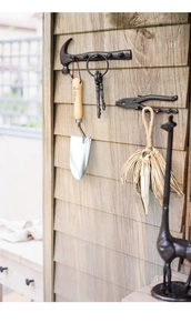 Industrial cast iron wall hooks in retro hammer and pliers shapes on wooden planks