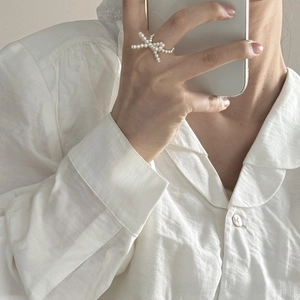 Close-up of S925 silver pearl bow ring on finger for a French vintage elegant look