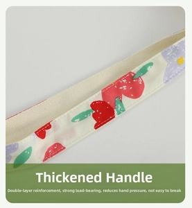 Detail of thickened reinforced handle with strawberry print and sturdy stitching on canvas bag