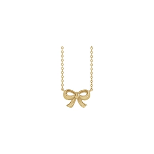 Detail of polished gold bow pendant on a delicate chain necklace for women