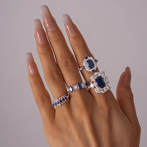 Detail of vintage silver rings set with blue emerald-cut stones and white zircon accents