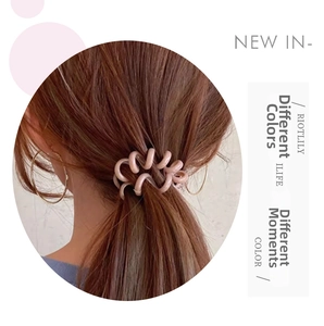 Close-up of a pink spiral telephone cord hair tie used for a high ponytail hairstyle