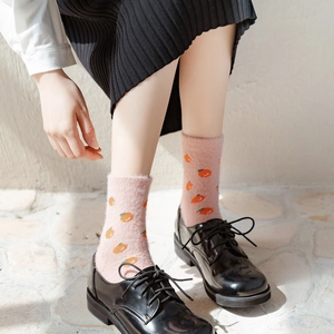 Plush pink winter socks with orange pattern paired with black shoes for warm home wear